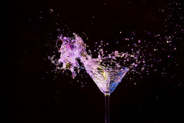 High Speed Splash Photography. Burst of Colorful Liquid in Wine Glass. Isolated Over Black.