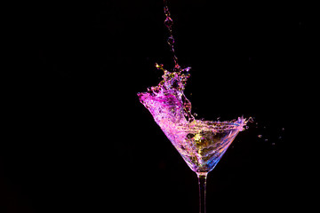High Speed Splash Photography. Droplets Along With Burst of Colorful Liquid in Wine Glass. Isolated Over Black.