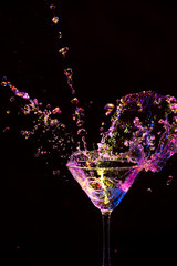 Splash Photography. Droplets Along With Burst of Colorful Liquid in Wine Glass. Isolated Over Black.