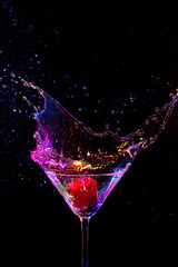 Explosion of Colorful Liquid in Wine Glass with Strawberry. Isolated Over Black Background.