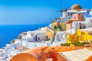 Popular Travel Destinations. Picturesque Cityscape of Oia Village in Santorini Island Located on Volcanic Calderra at Daytime. Traditional Windmills on Background.
