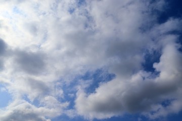 Beautiful fluffy white clouds covered in sunlight on a deep blue sky 