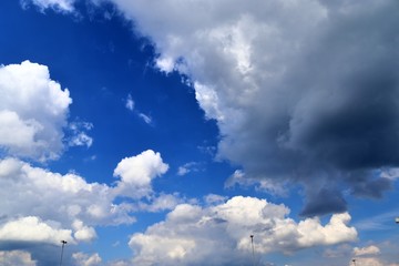 Beautiful fluffy white clouds covered in sunlight on a deep blue sky 