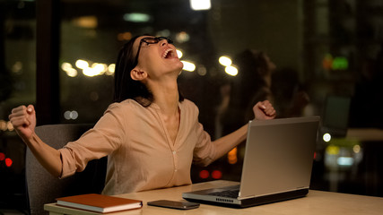 Happy female worker showing success gesture, startup promotion, achievement