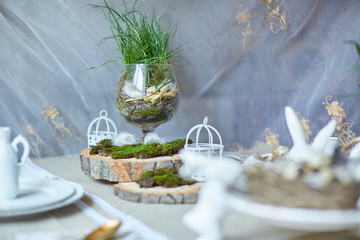Easter table set. Decorated with eggs, nests and flowers.