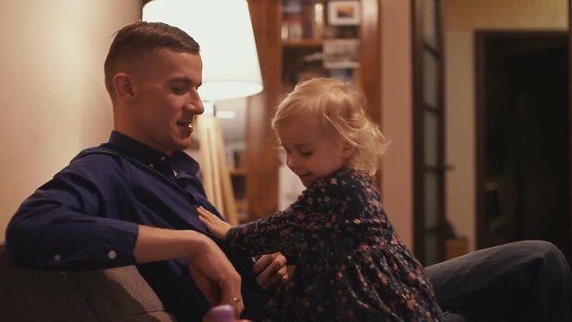 Young father spends time with his little daughter at home