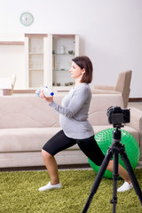 Fototapeta na wymiar Pregnant woman blogger doing physical exercises 