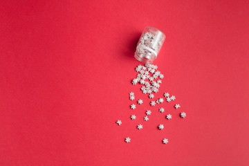 collection of tiny little snowflakes isolated on the red background. creative design concept. body care. minimal style