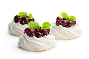 Mini Pavlova meringue nests with cranberry and mint leaves isolated on white