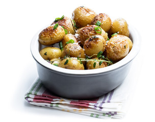 Baked baby potatoes with spices in a bowl on gray stone table
