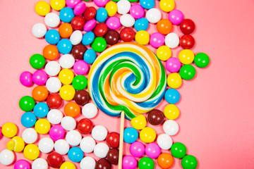 Fototapeta na wymiar Colorful lollipops and different colored round candy. Top view blue pastel background