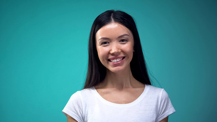 Fototapeta premium Portrait of beautiful asian woman looking at camera, isolated on blue background