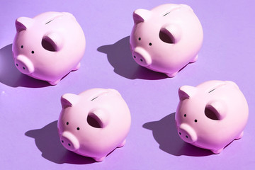 four plastic moneyboxes on the blue background, side view. baby gift.handmade souvenirs, teaching, learning financial knowledge for children