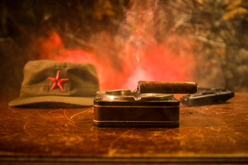 Close up of a Cuban cigar and ashtray on the wooden table. Communist dictator commander table in...