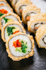 sushi, japanese food, deluxe restaurant menu, delicious traditional seafood. philadelphia and vegetarian tempura sushi rolls, served on black plate