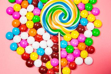 Fototapeta na wymiar Colorful lollipops and different colored round candy. Top view blue pastel background