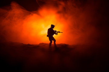 Military soldier silhouette with gun. War Concept. Military silhouettes fighting scene on war fog...