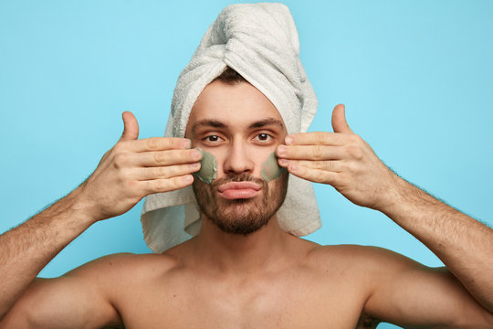 Young Serious Confident Man With Anti Aging Cream On The Face.funny Guy With War Paint Looking At The Camera