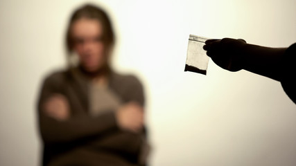Hand showing packet with powder, harmful health effect, addiction will power