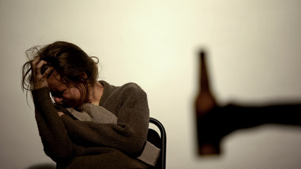 Hand showing bottle with beer alcohol addicted woman, rehabilitation, willpower