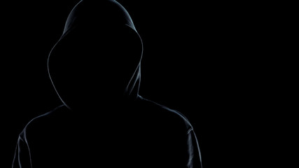 Close up of faceless male silhouette standing against black background, criminal - obrazy, fototapety, plakaty