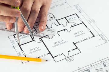 Male hands, Orange helmet, pencil, architectural construction drawings, tape measure. The architect designs the building. The concept of architecture, construction, engineering, design. Copy space.