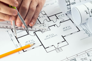 Male hands, Orange helmet, pencil, architectural construction drawings, tape measure. The architect designs the building. The concept of architecture, construction, engineering, design. Copy space.