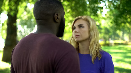 Sorrowful woman looking at afro-american man, break up because of prejudices