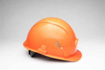Fototapeta premium Orange construction helmet on a light background. The concept of architecture, construction, engineering, design. Copy space.
