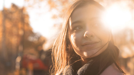 Happy motivated young lady smiling to pleasant autumn sun, feeling inspiration