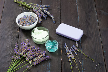 hygiene and skin care product samples with lavender flowers on black wooden
