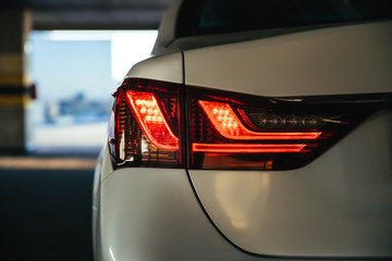 Obraz premium Modern car safe red led taillights in the parking lot