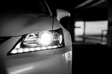 Headlamp of modern car. Close up detail in black and white