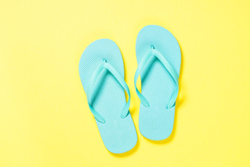 Blue flip flops on yellow background.