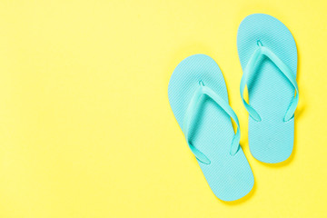 Blue flip flops on yellow background.
