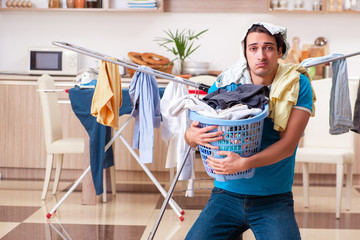 Young man husband doing clothing ironing at home