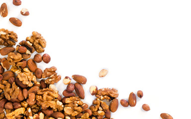 Background of mixed nuts - hazelnuts, walnuts, almonds - with copy space. Nuts isolated one edge....