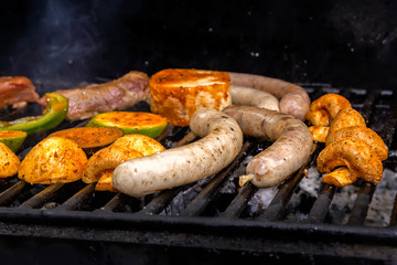 Sausages, meat steak, vegetables, mushrooms are cooked on a charcoal grill. Street food. Close-up