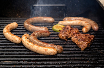 Sausages and meat steak are grilled over charcoal. Street food