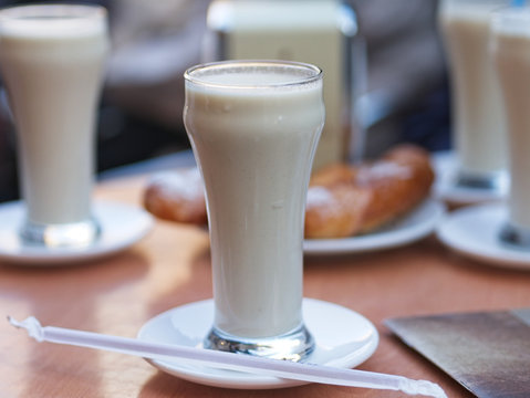 Glasses of Horchata de Chufa on a wooden table. It is a Mediterranean tradition of grain-based beverages and is made with dried and sweetened tiger nuts.