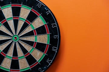 target dart board on the table with orange background, center point, head to target marketing and...