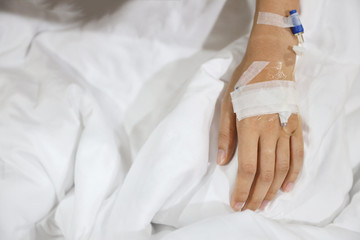 Fototapeta na wymiar patient woman hand lying down on hospital bed with saline needle