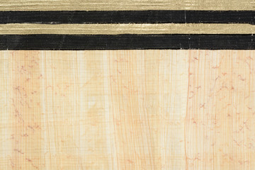 Authentic Egypt papyrus paper background with horizontal gold and black lines. Close up macro...