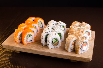 Japanese cuisine in the Ukrainian restaurant. Set sushi rolls with fish tuna, eel, salmon. Maki rolls on a wooden plate. Seafood Restaurant Menu