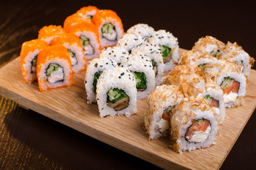 Japanese cuisine in the Ukrainian restaurant. Set sushi rolls with fish tuna, eel, salmon. Maki rolls on a wooden plate. Seafood Restaurant Menu