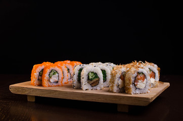 Japanese cuisine in the Ukrainian restaurant. Set sushi rolls with fish tuna, eel, salmon. Maki rolls on a wooden plate. Seafood Restaurant Menu