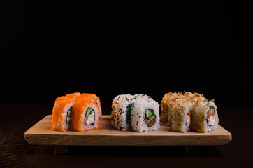 Japanese cuisine in the Ukrainian restaurant. Set sushi rolls with fish tuna, eel, salmon. Maki rolls on a wooden plate. Seafood Restaurant Menu