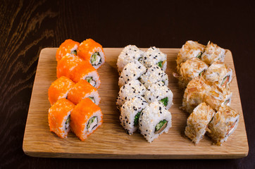 Japanese cuisine in the Ukrainian restaurant. Set sushi rolls with fish tuna, eel, salmon. Maki rolls on a wooden plate. Seafood Restaurant Menu