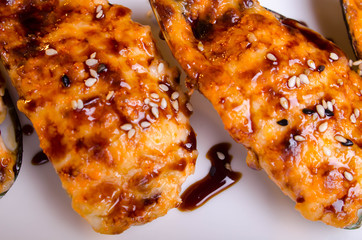 Menu of Ukrainian seafood restaurant. Baked mussels with garlic and cheese. Poured with sauce and sprinkled with sesame. Tasty lunch