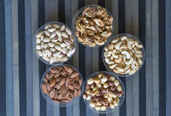 Obraz premium Healthy food. Nuts mix assortment on stone texture top view. Collection of different legumes for background image close up nuts, pistachios, almond, cashew nuts, peanut, walnut. image
